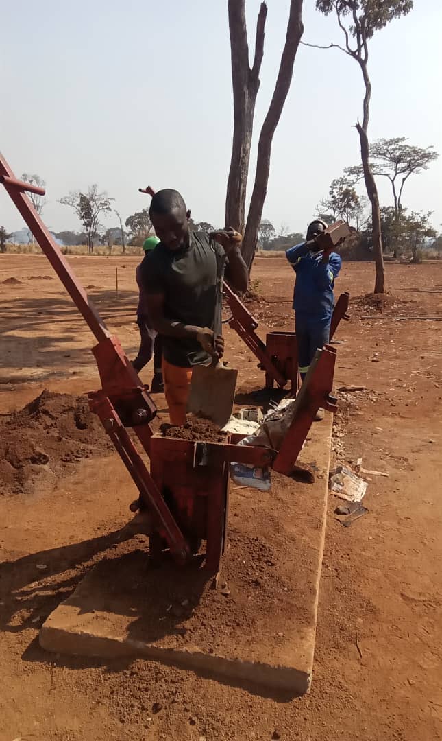 photograph of two students learning to manufacture bricks